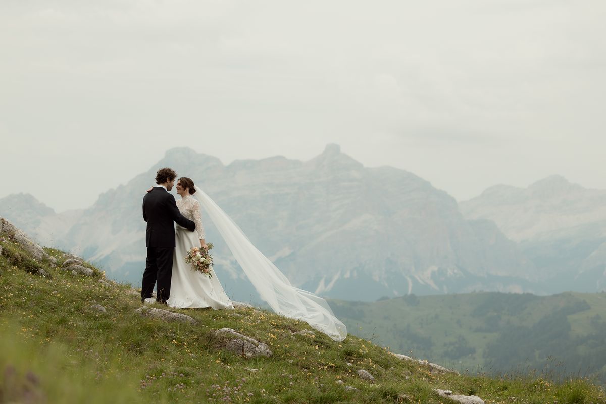 Couple with a veil on a meadow below the Dolomites