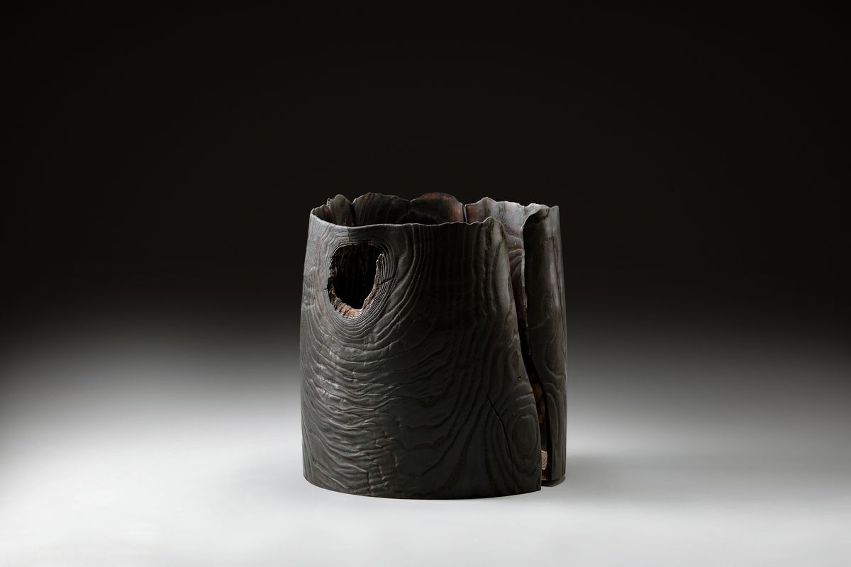Dark wooden vessel with an irregular rim