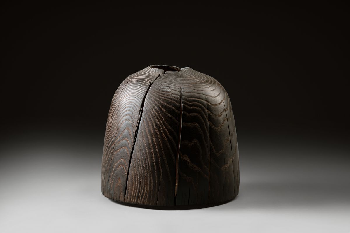 Blackened wooden vessel with cracks