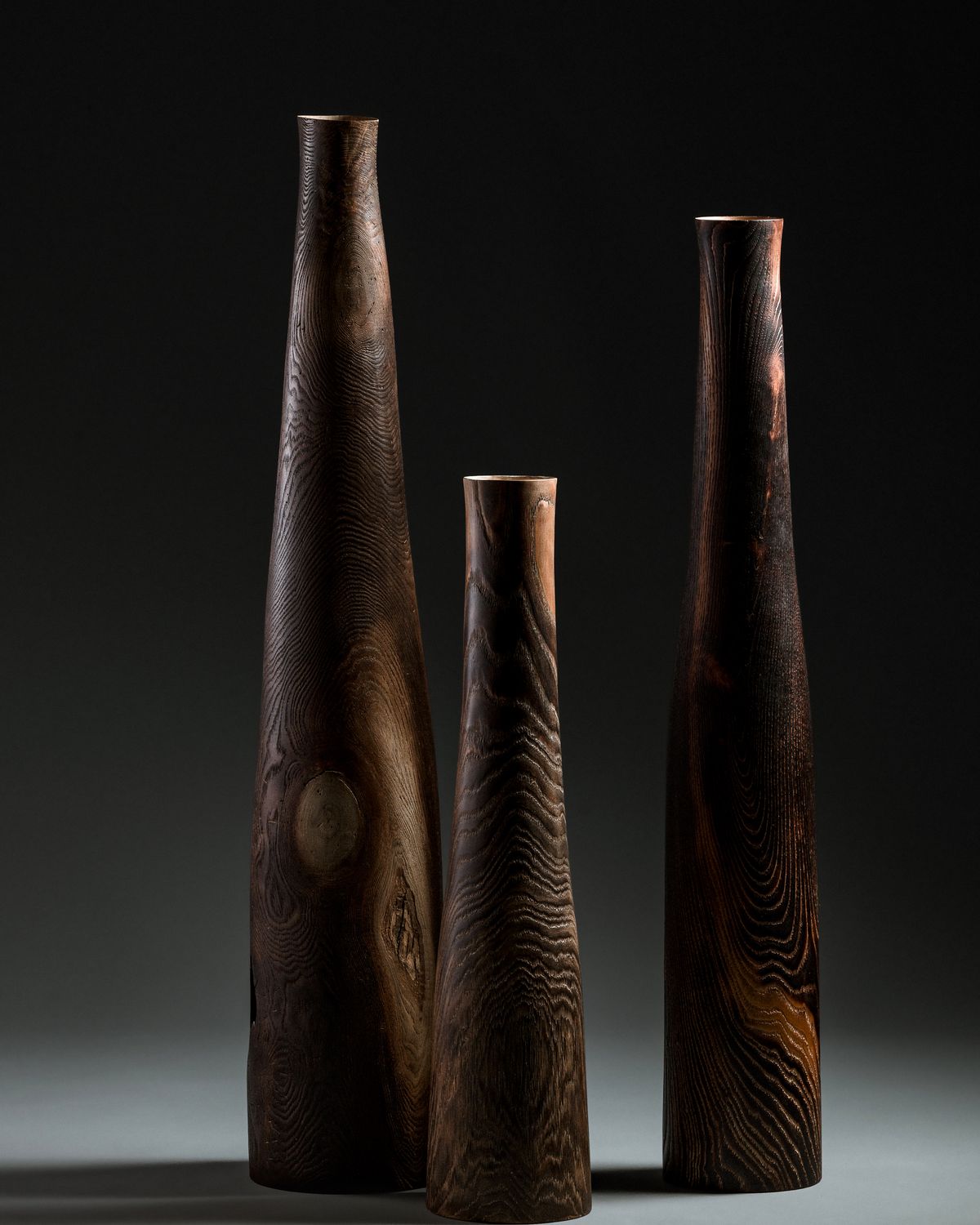 Three tall wooden vases