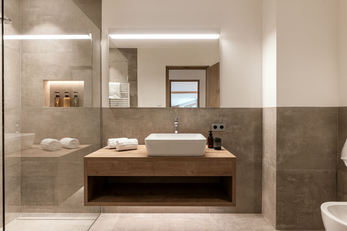 Bathroom with stone wall and wooden vanity