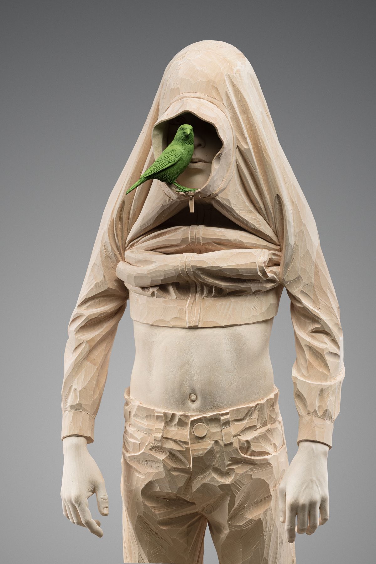Wooden figure with hood and bird