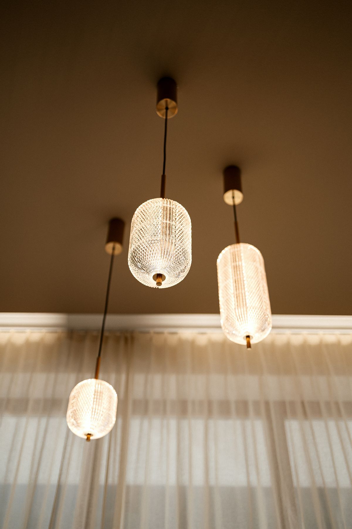 Glass pendant lights in front of the curtain