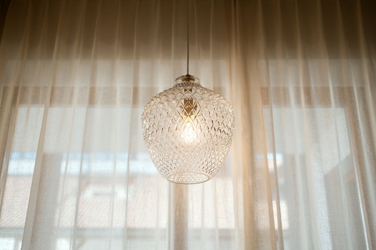 Glass pendant light in front of the curtain
