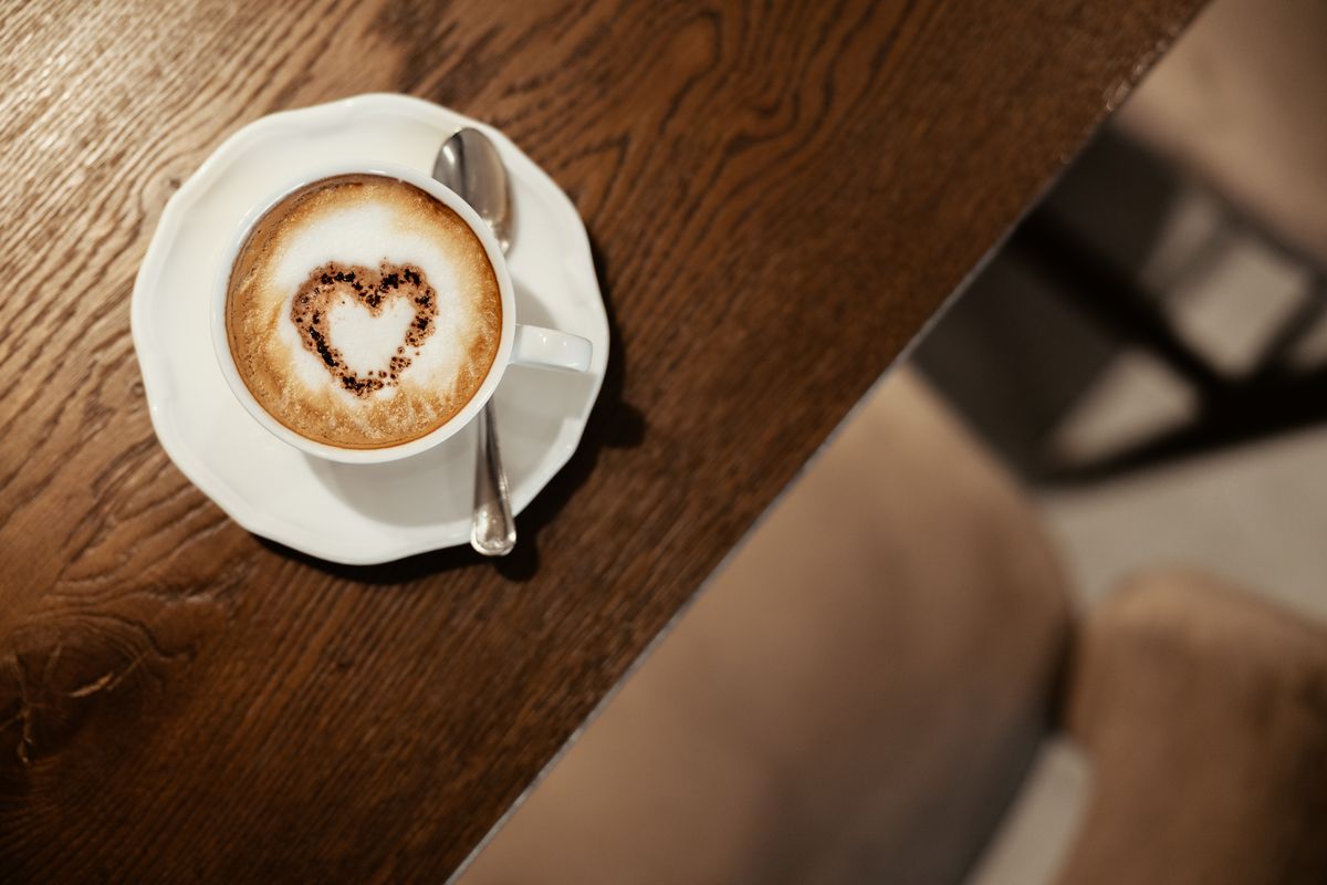 Cappuccino with a heart on the wooden table