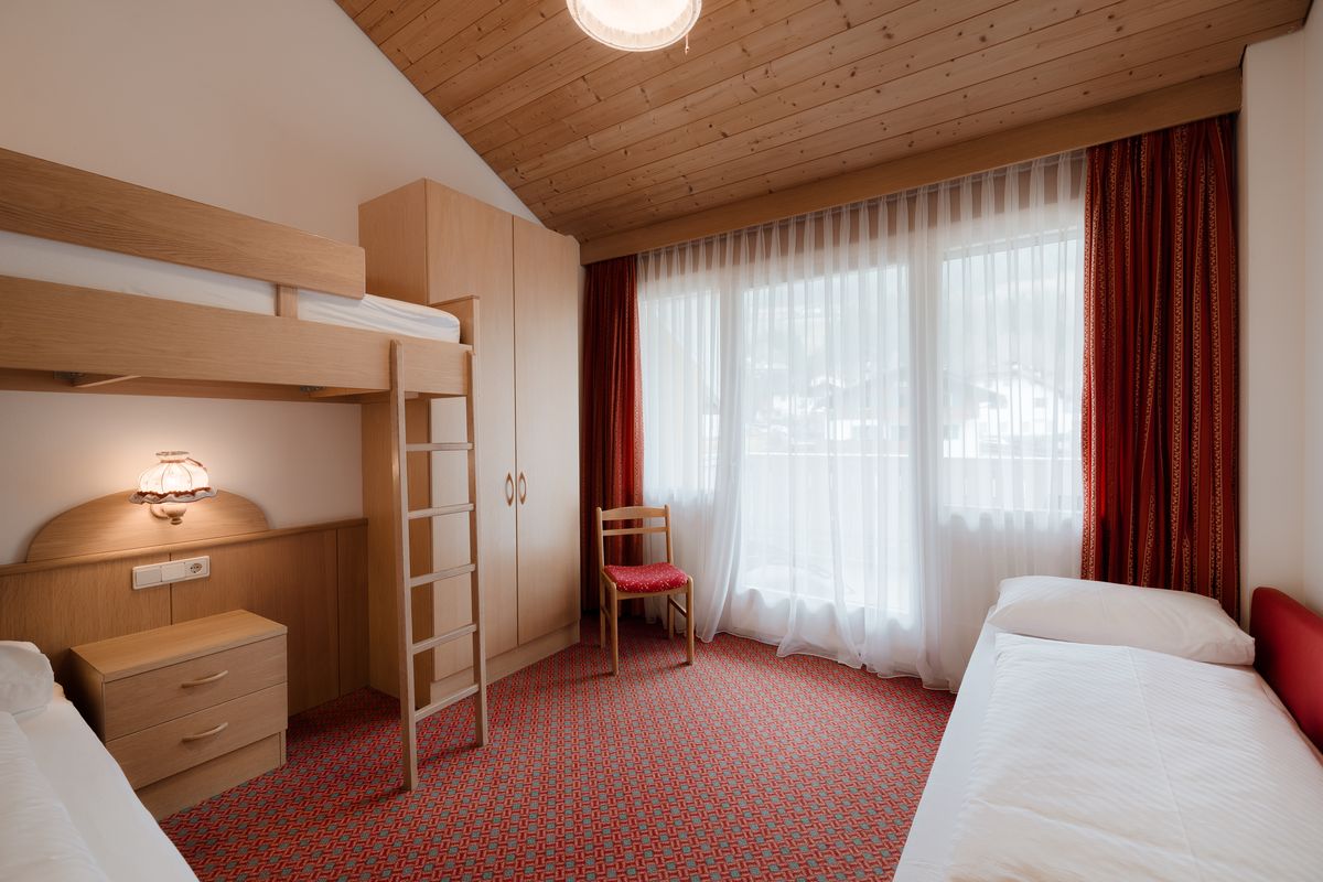 Room with loft bed and red curtain