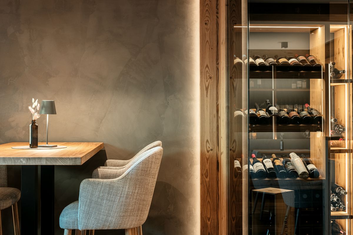 Table in front of the lit wine rack