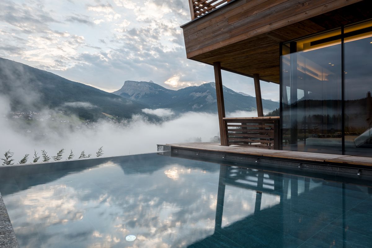Infinity pool in morning mist above the valley