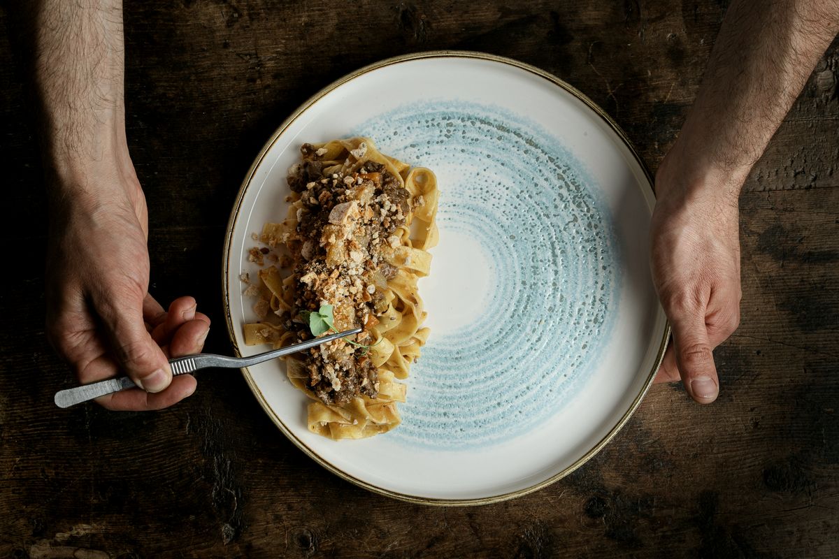 Pasta with ragù on a pale blue plate