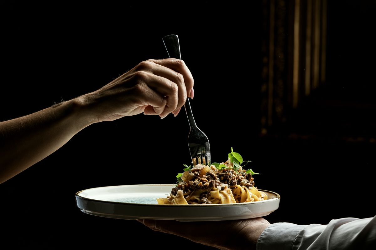 Fork lifting pasta above the plate