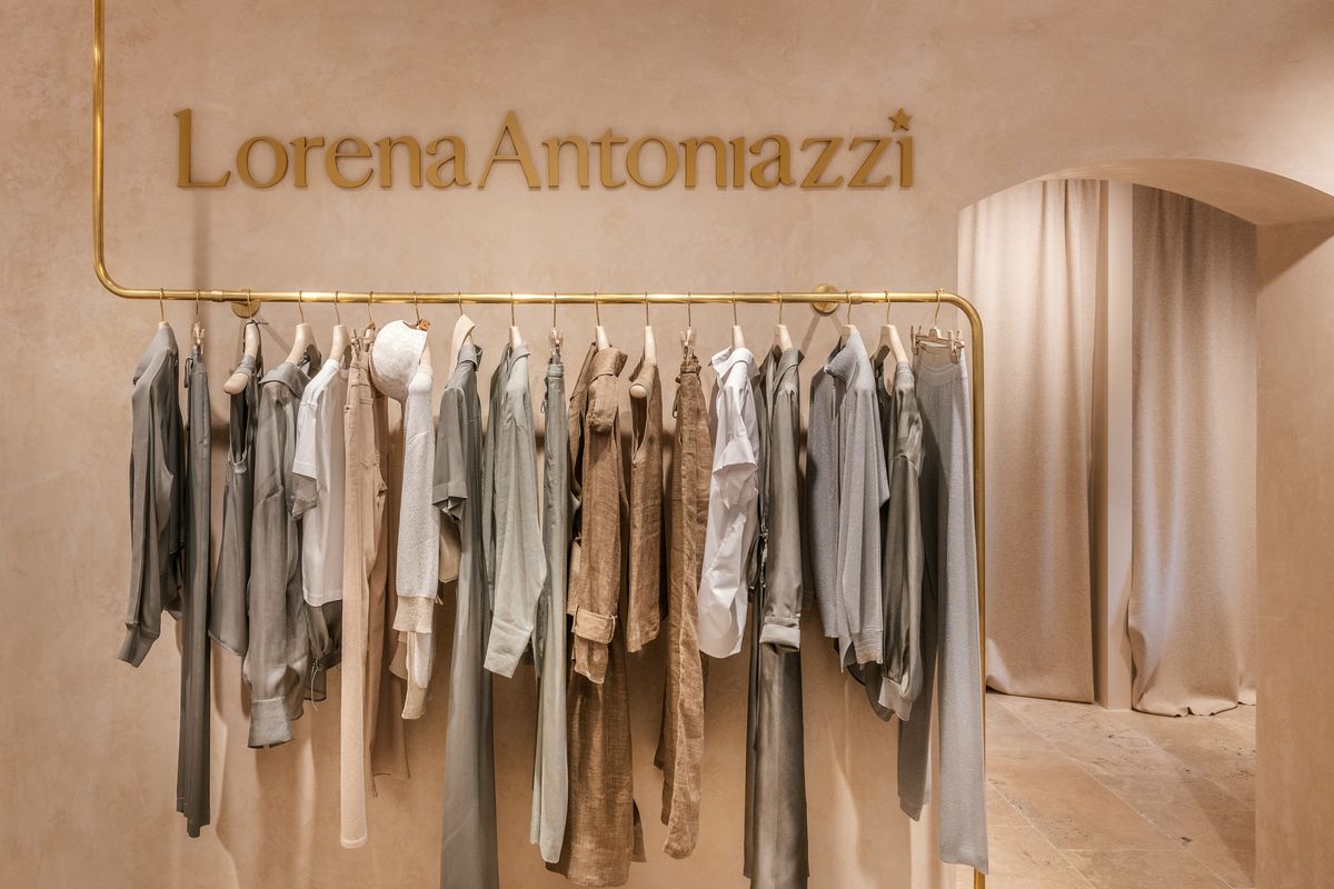 Clothing rail in front of the logo on the wall