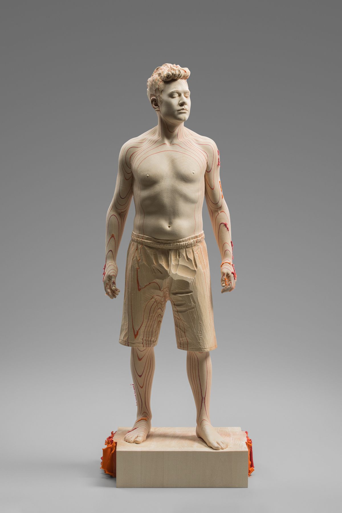 Standing wooden figure of a young man