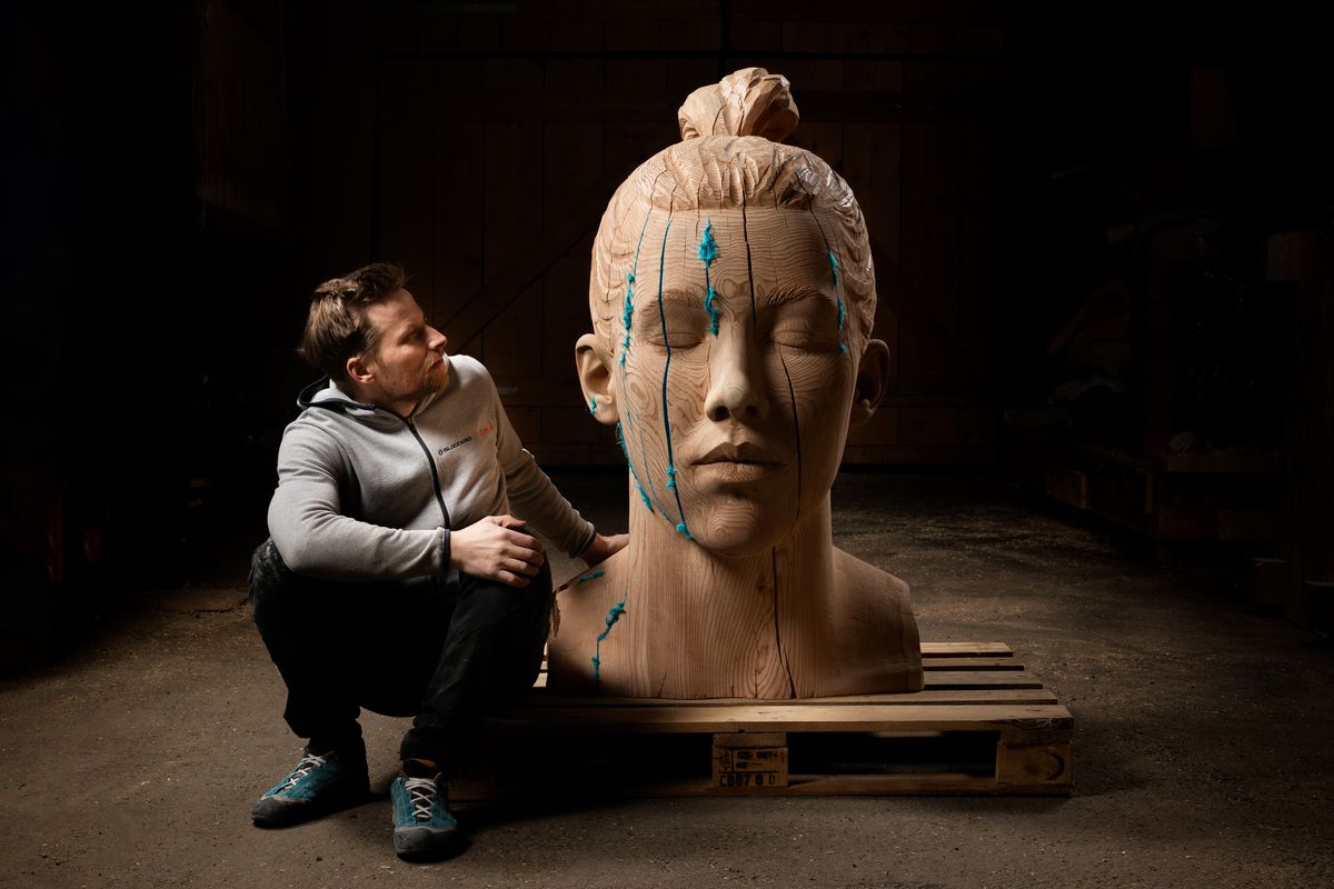 Sculptor beside a large sculpted head