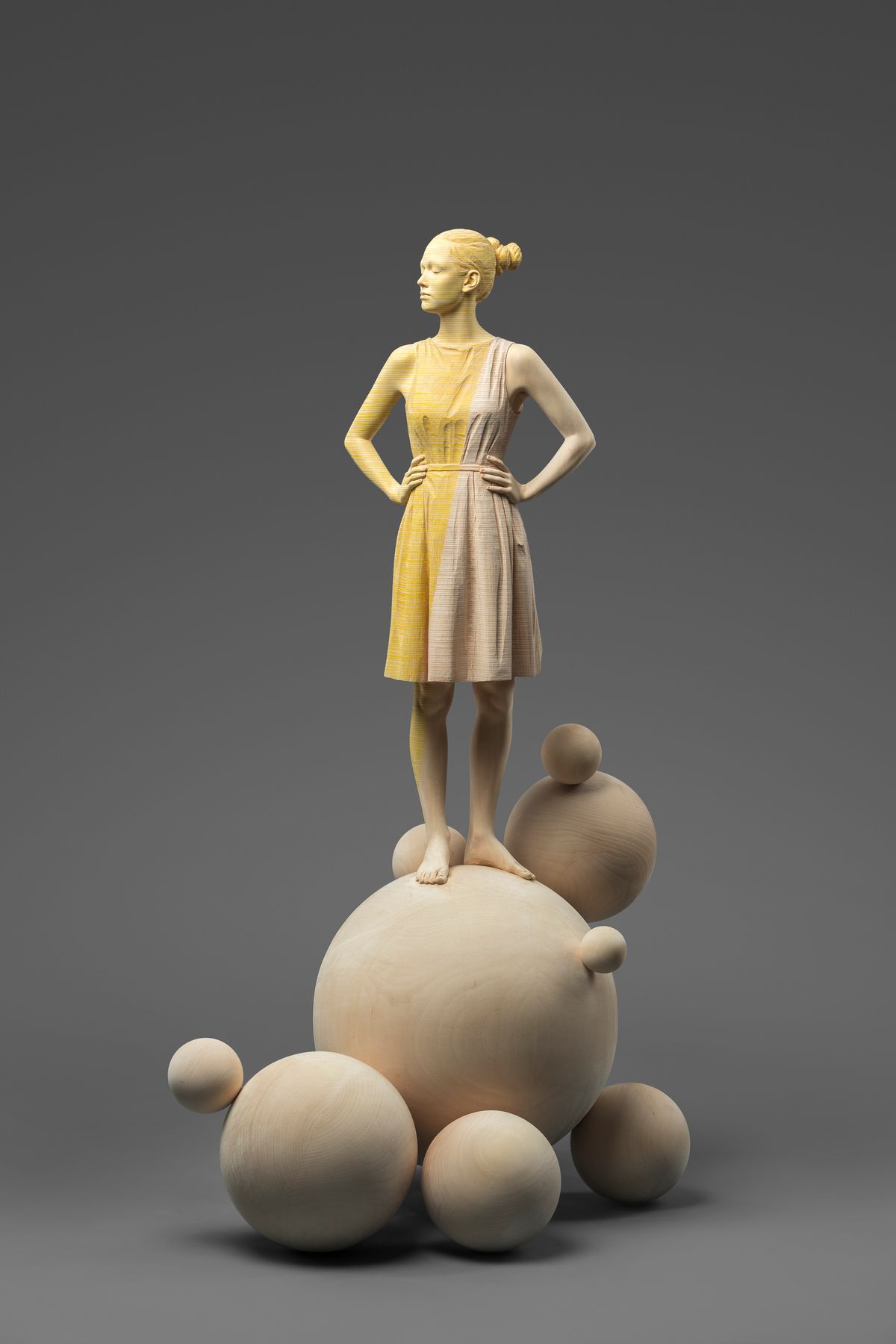 Female figure standing on spheres