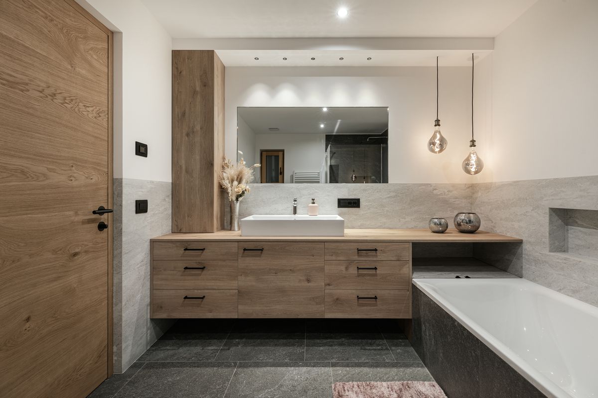Bathroom with wooden furniture and bathtub
