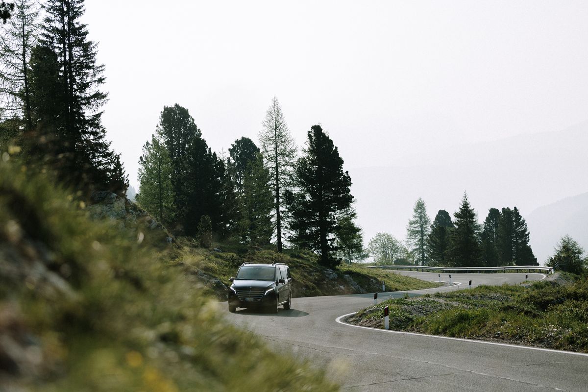 Van between larches on the pass road