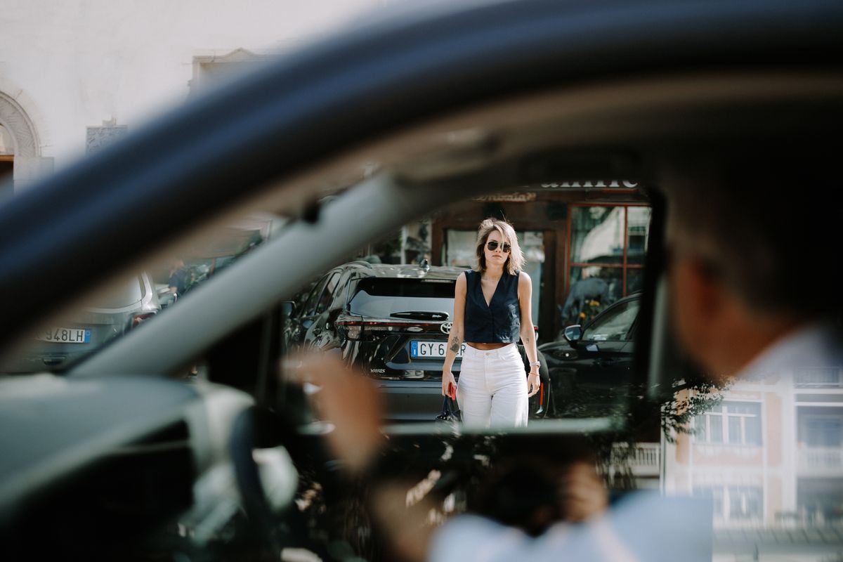Guest approaching the car, reflected in the window