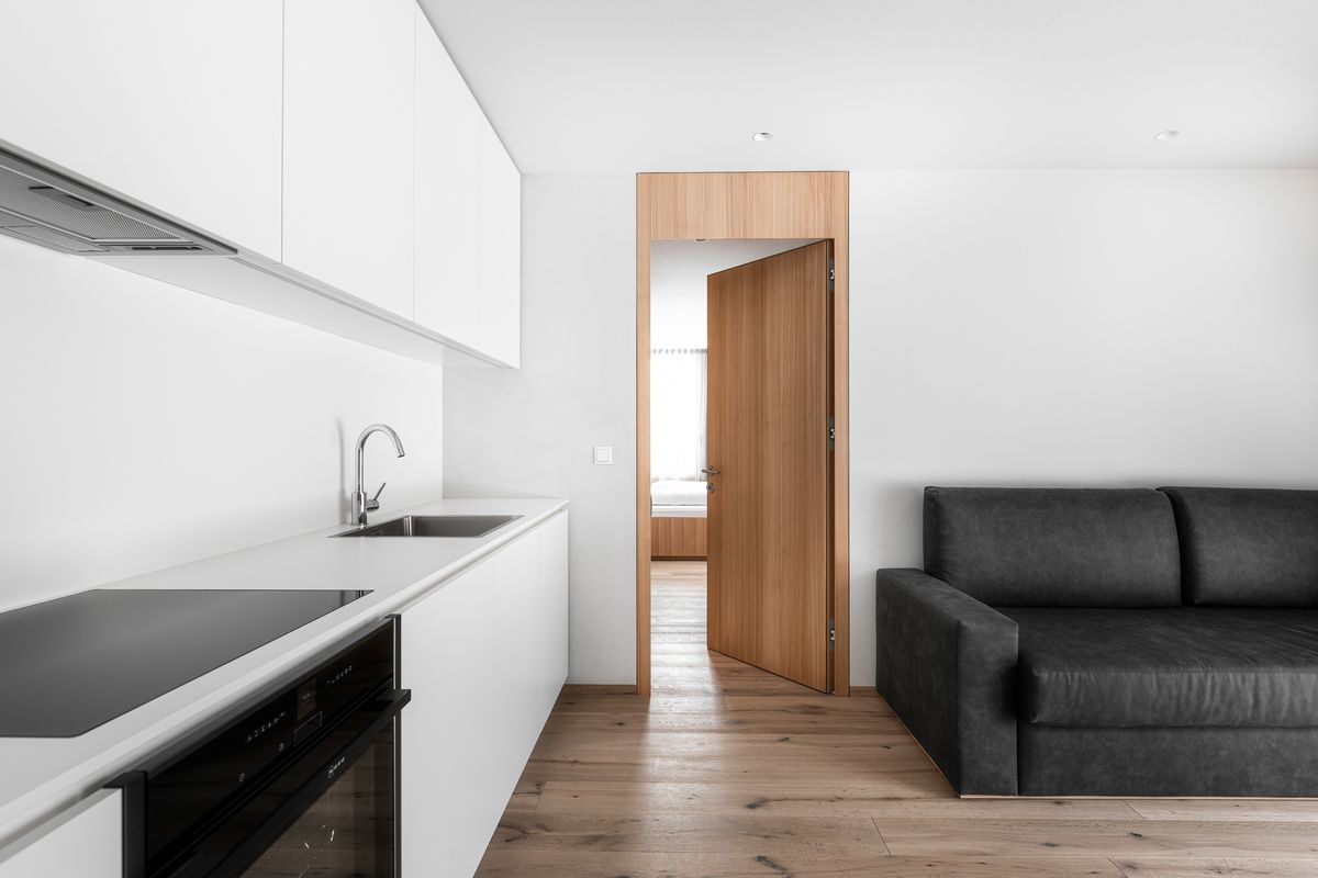 Kitchen with white fronts and wooden door