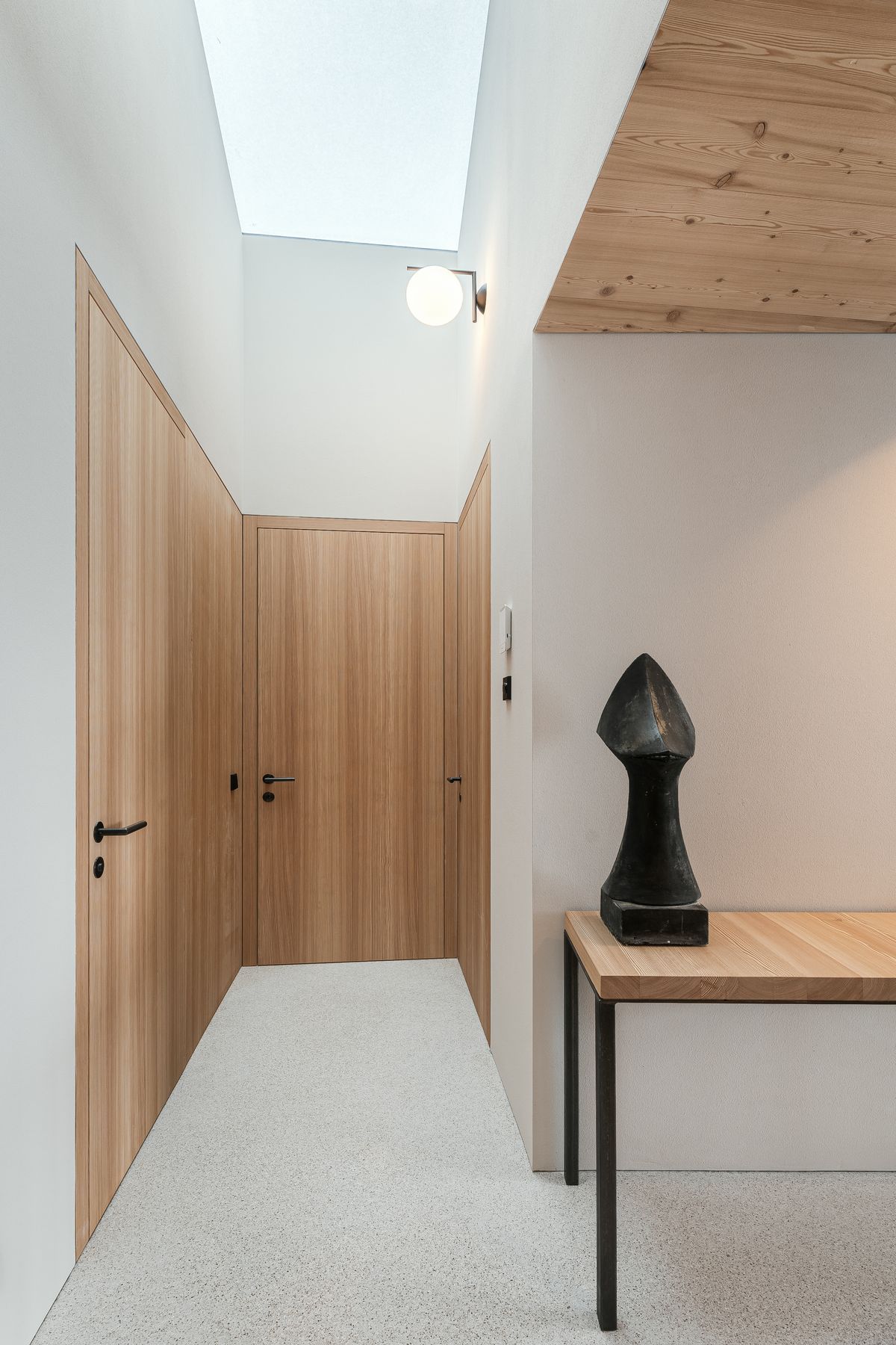 Hallway with skylight and wooden doors