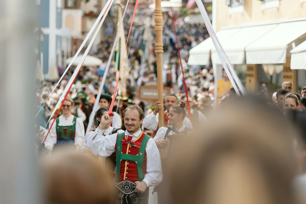 Festumzug mit geschmückten Stangen
