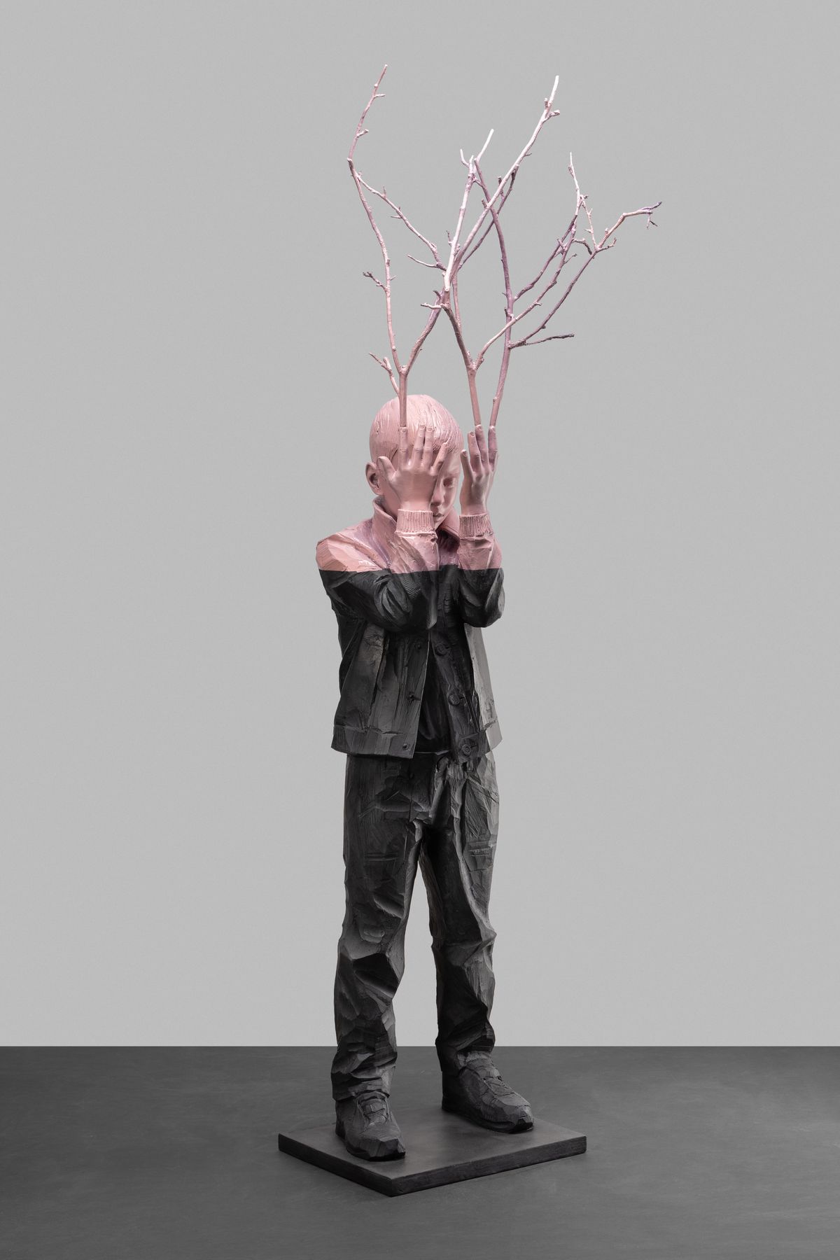 Figure with branches in front of the face