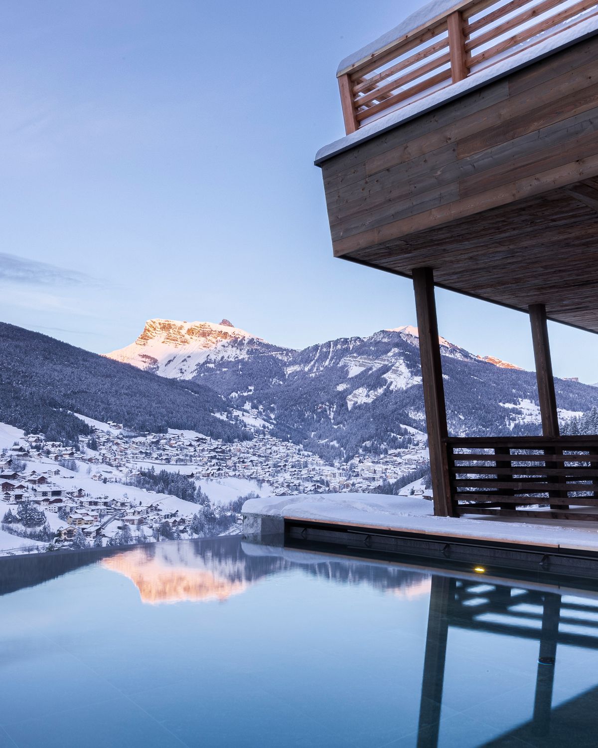 Infinity pool in the snow at blue hour with mountain views