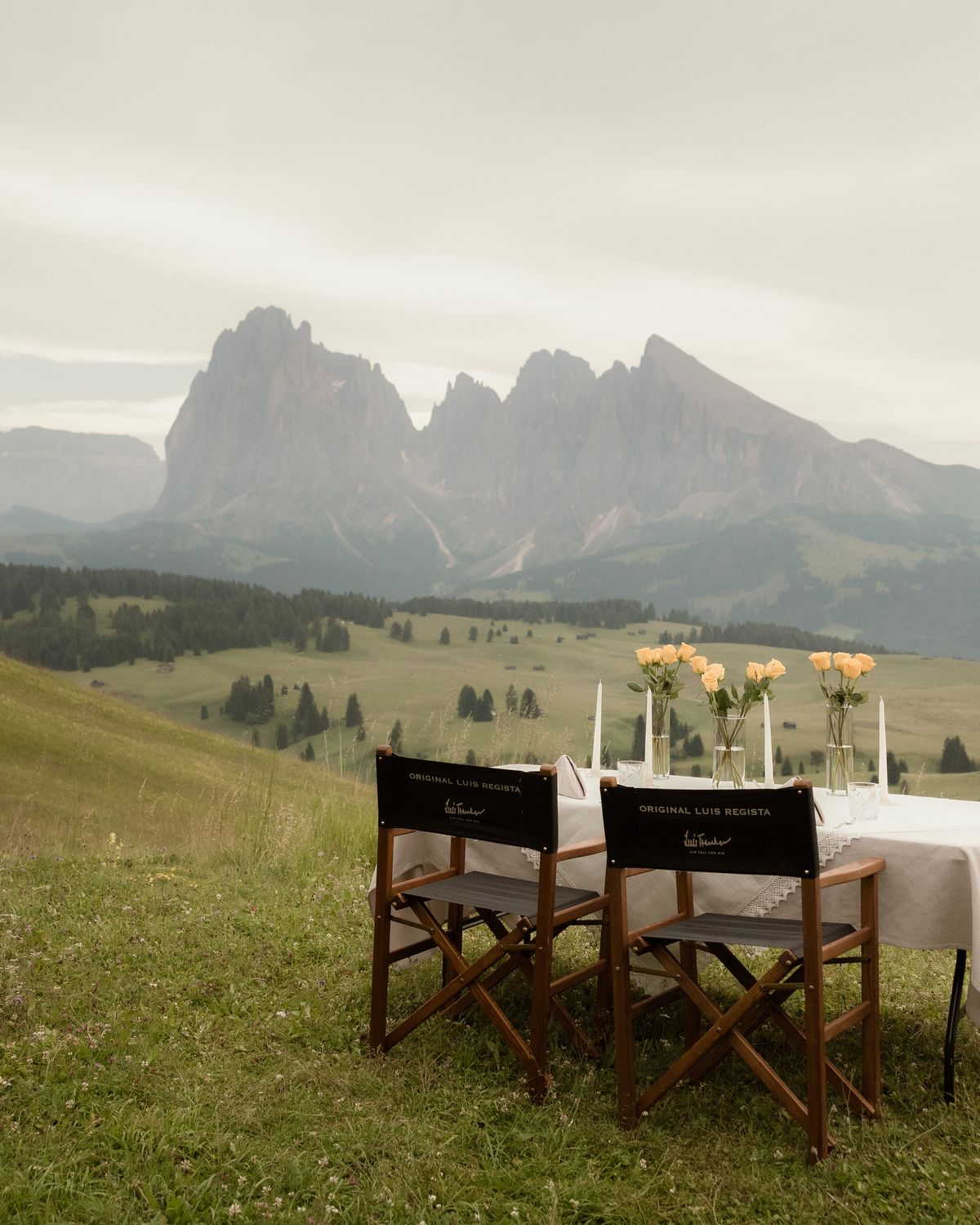 Gedeckter Tisch mit zwei Regiestühlen auf der Seiser Alm vor dem Langkofel