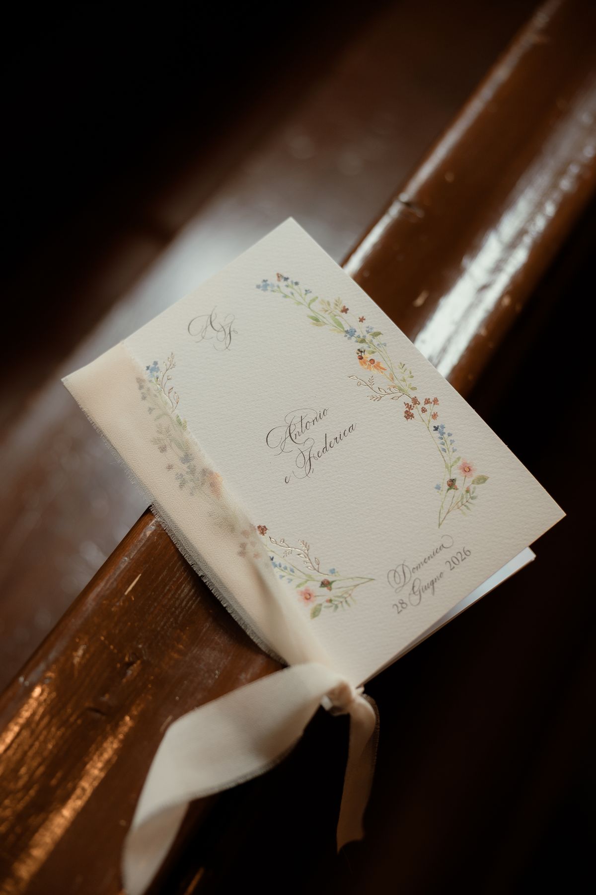 Order of service with a floral watercolour on a pew