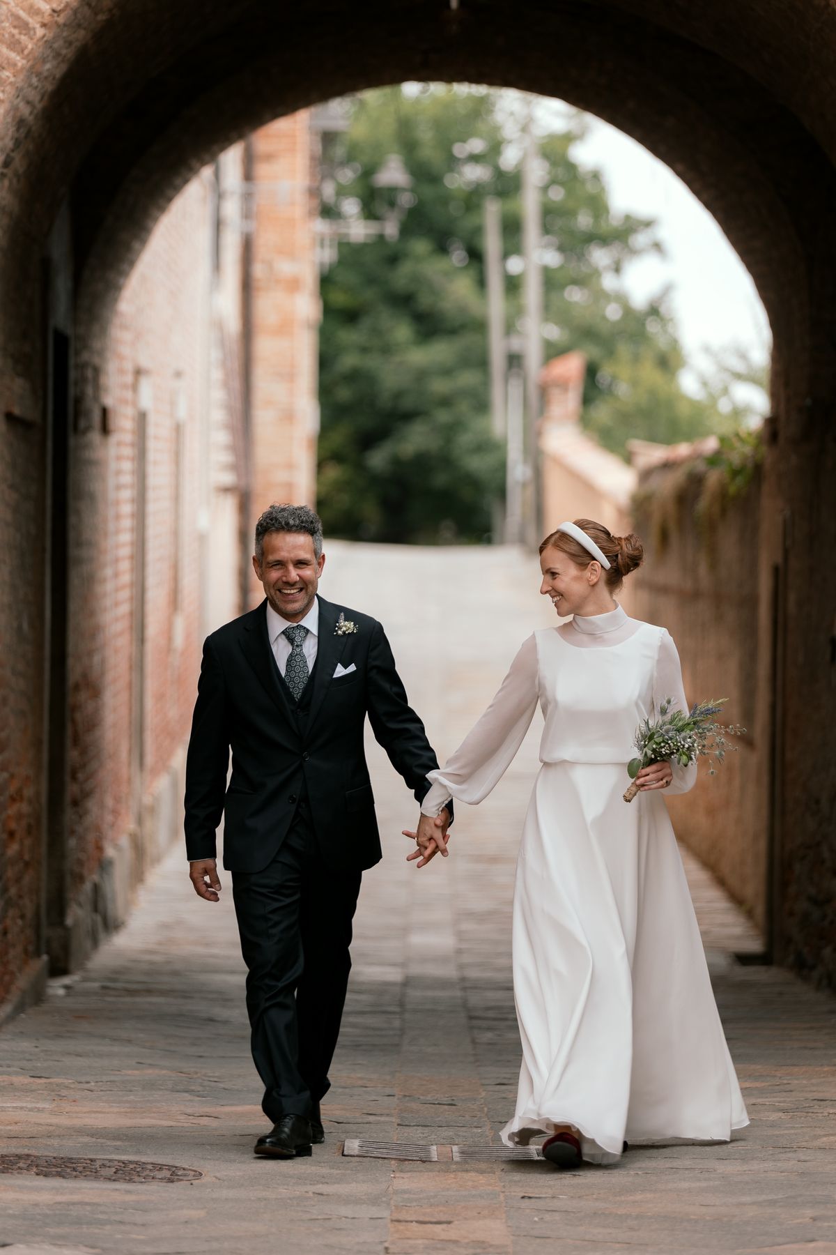 Couple walking hand in hand through an archway