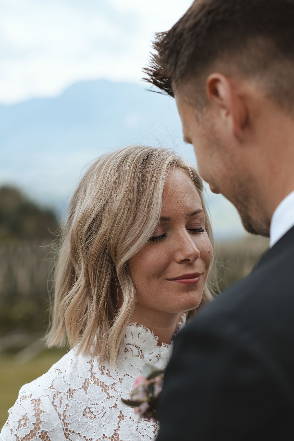 Bride smiling with closed eyes next to the groom