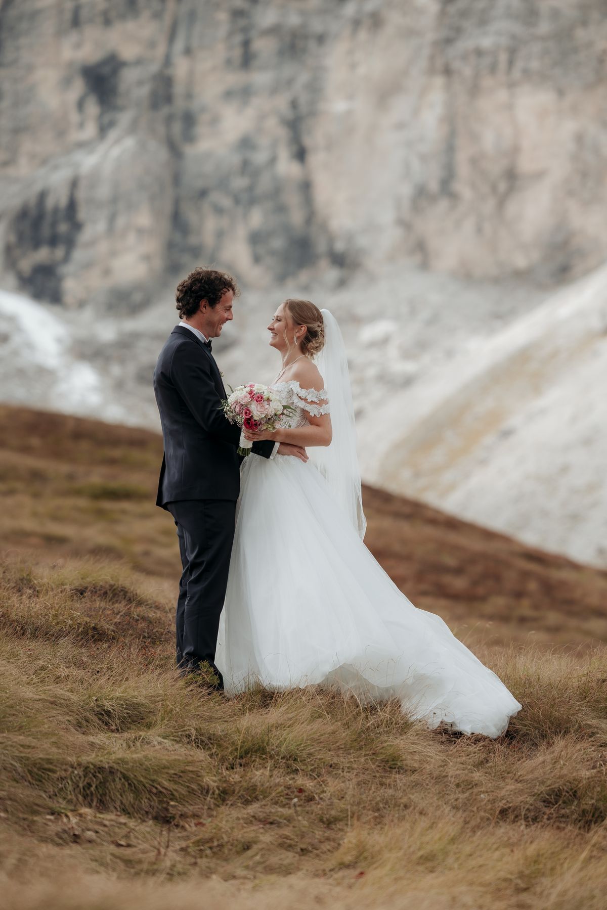 Couple below rock walls in autumn grass