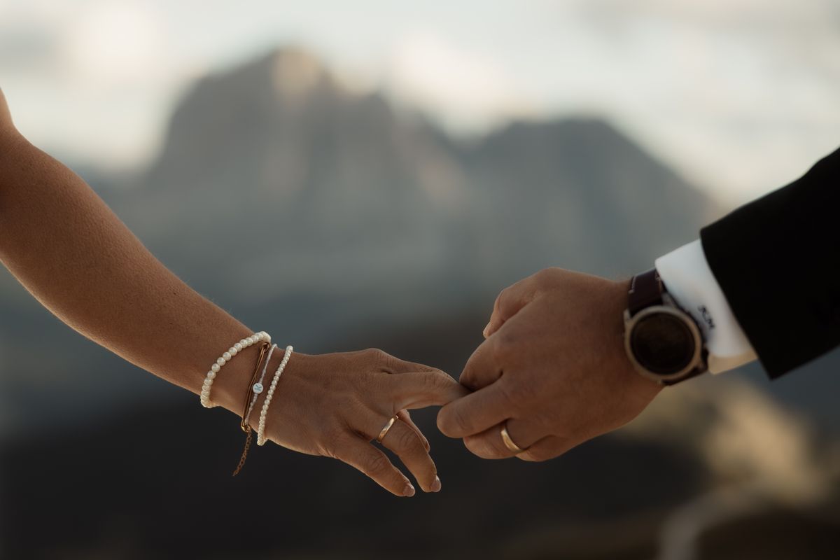 The couple’s hands against the mountains