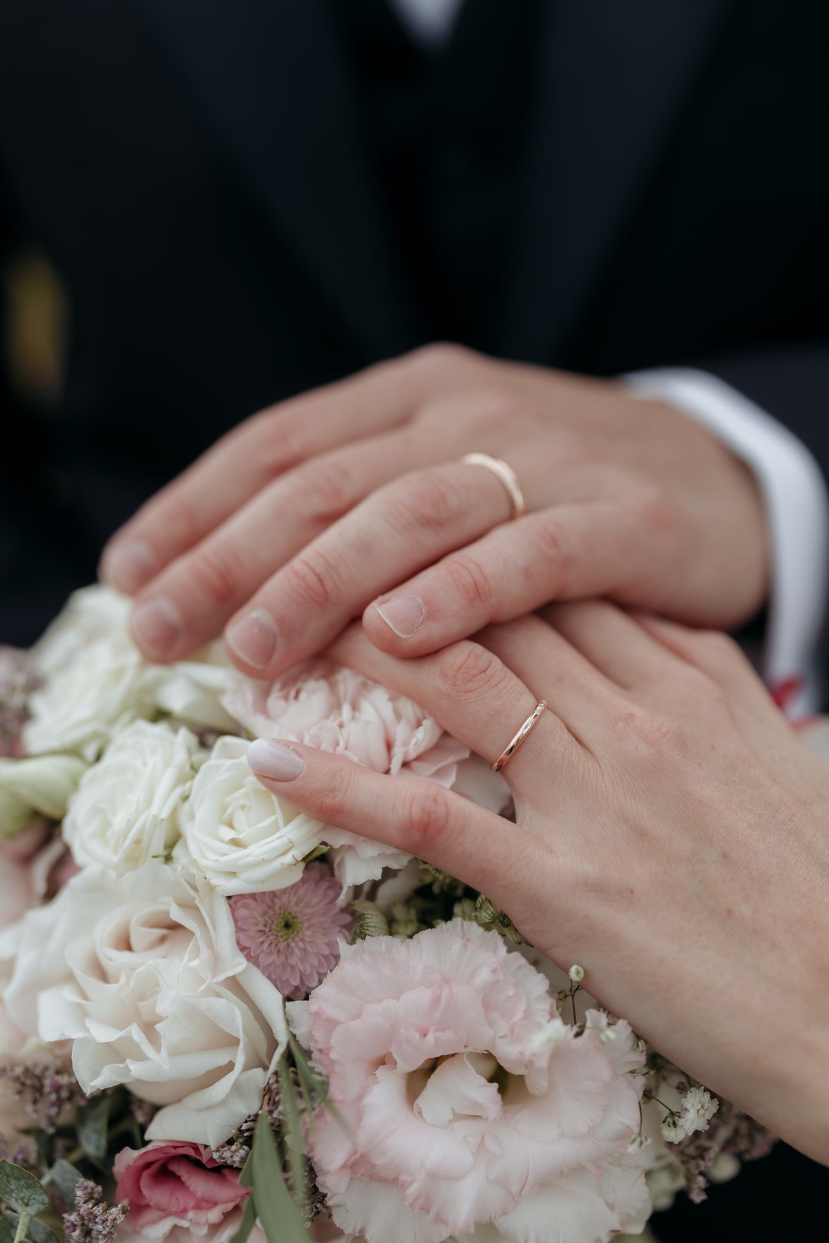 Hands with rings resting on the bouquet